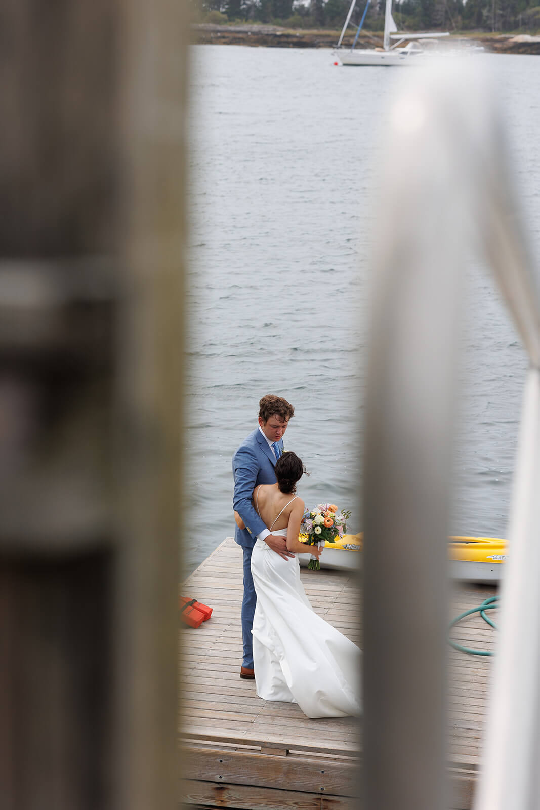 Intimate waterfront wedding portrait of a bride and groom on the dock at Sebasco Harbor Resort.