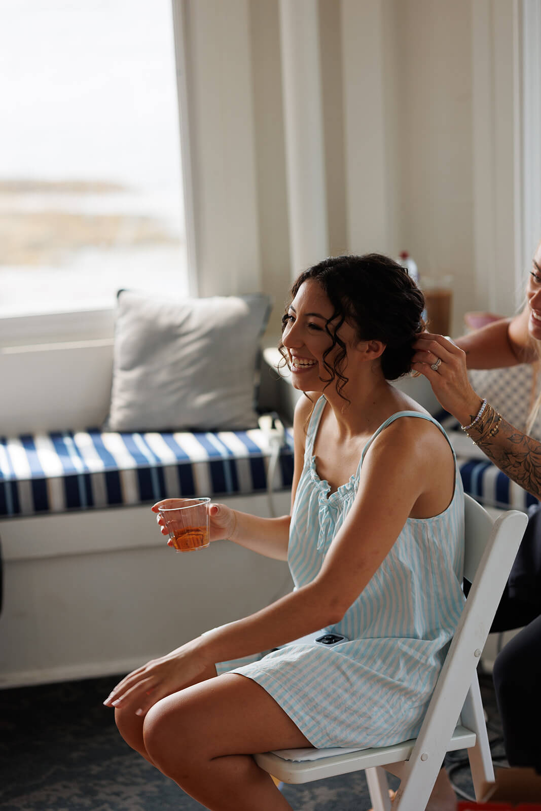 Bride laughing during hair and makeup preparations before her coastal Maine micro wedding.