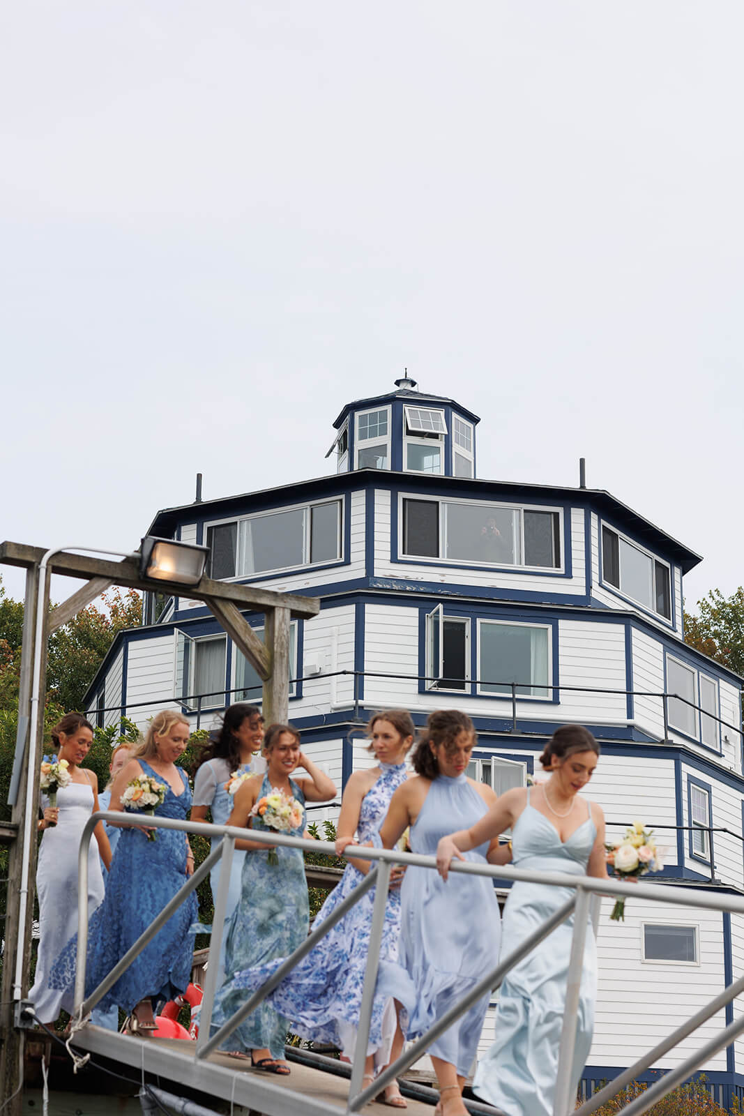 Bridesmaids walking down the marina ramp during a coastal Maine wedding weekend.