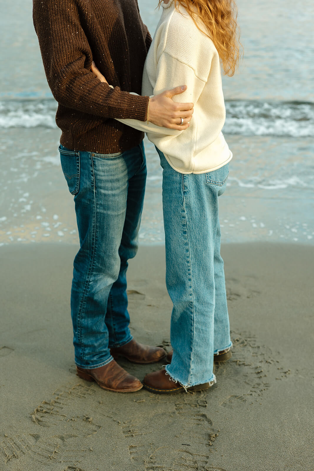 Golden hour engagement photoshoot image of a couple embracing on the beach in coastal Maine
