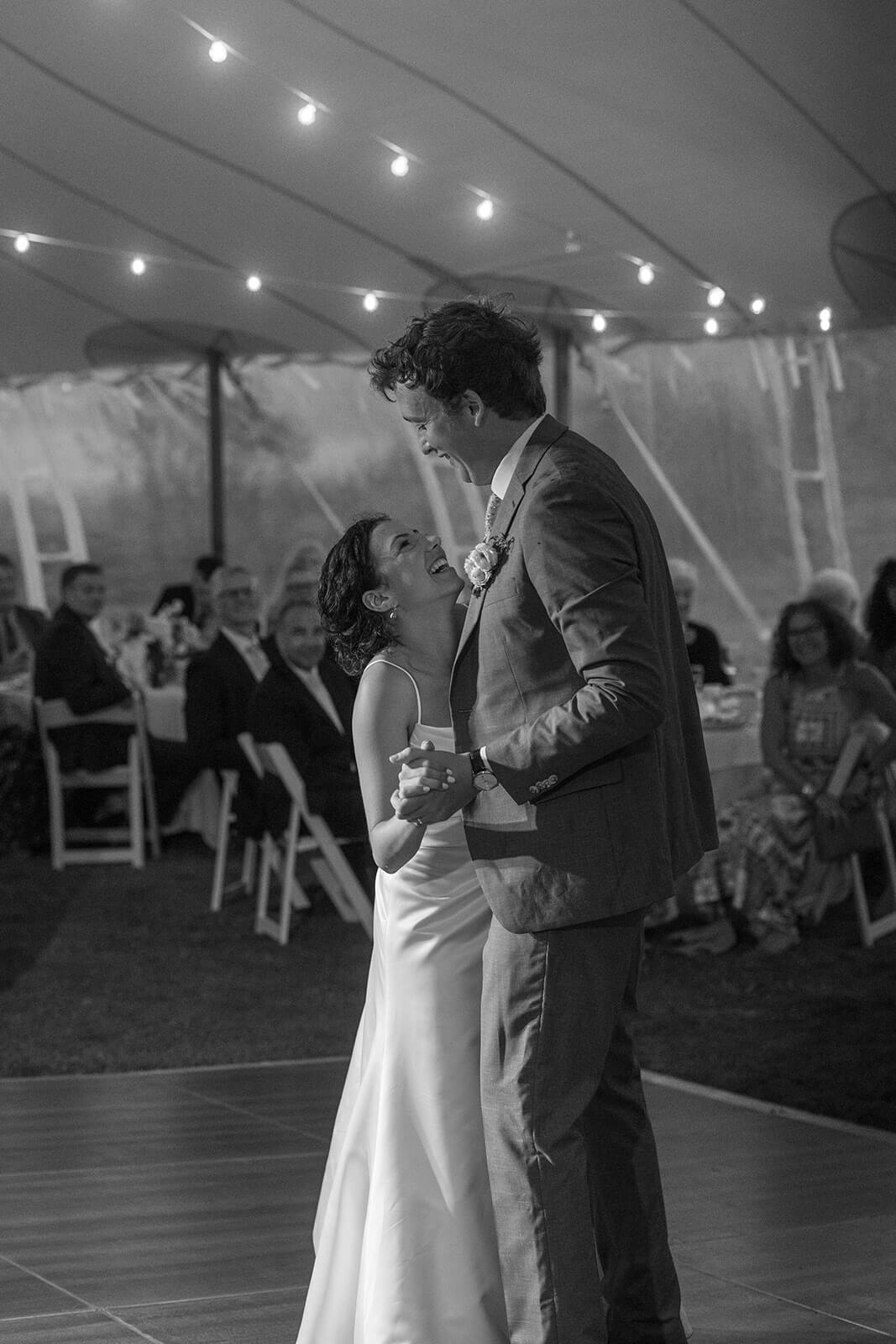Black and white photo of a bride and groom dancing during their intimate Maine wedding reception.